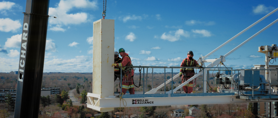 construction workers installing the counterweight on a tower crane